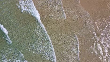 Vista-Aérea-De-Pequeñas-Olas-Rompiendo-En-La-Playa-De-Arena