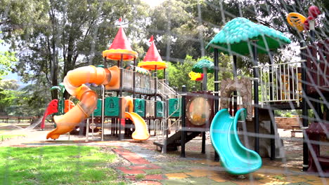 empty playground filmed through fence, panning shot