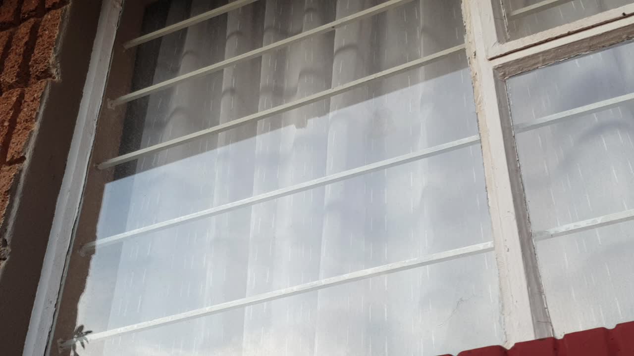 유리창 왼쪽으로 팬을 밀고 창틀이 천천히 움직이는 구름 반사