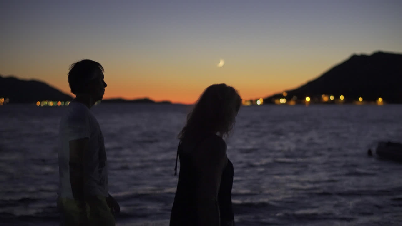 Two Adults Peacefully Walking By The Seaside In An Island At Dusk In Croatia. Selective Focus