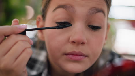 close-up of woman carefully using a brush to arrange her eyelashes, applying mascara or enhancing lash volume with focused precision for a flawless beauty routine and enhanced eye makeup