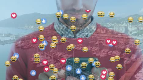 animation of emoji icons over caucasian man using smartphone