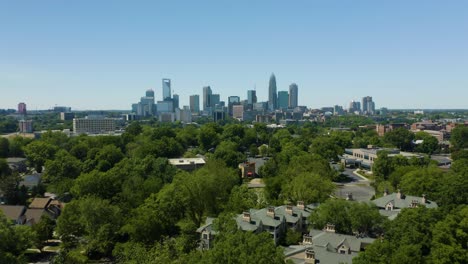 aerial hyperlapse above green tree tops with charlotte skyline in background
