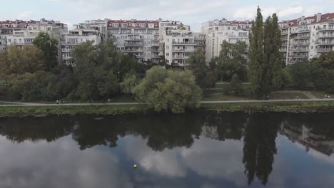 Drohne-Seitenschwenk-Luftbild-Von-Gebäuden-Und-Menschen-Neben-Dem-See-In-Warschau