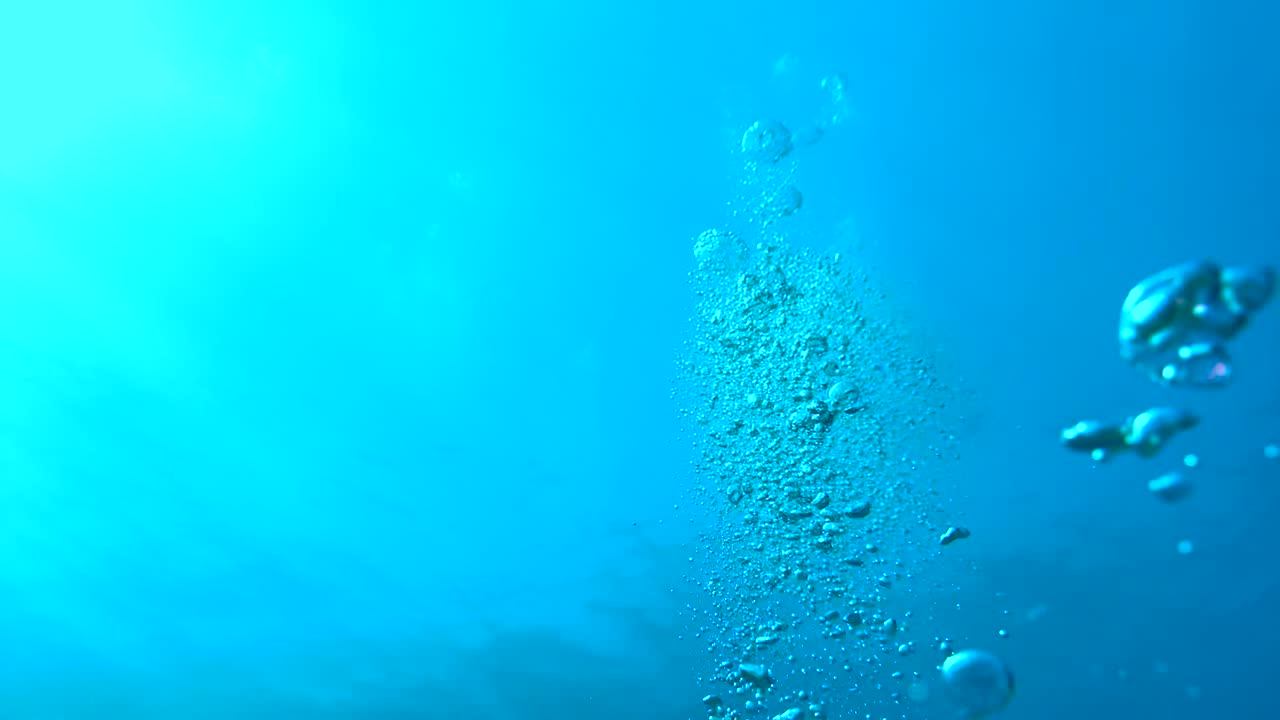 위에서 아오르는 빛은 깊은 크리스탈 은 바다 파란 물을 통과하여 아름다운 물을 일으키고, 빛의 반사, 공기 거품이 표면으로 상승하는 커튼을 일으킨다.