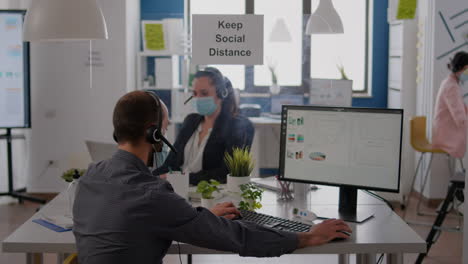 coworkers with headphones talking into microphone while working at financial statistics