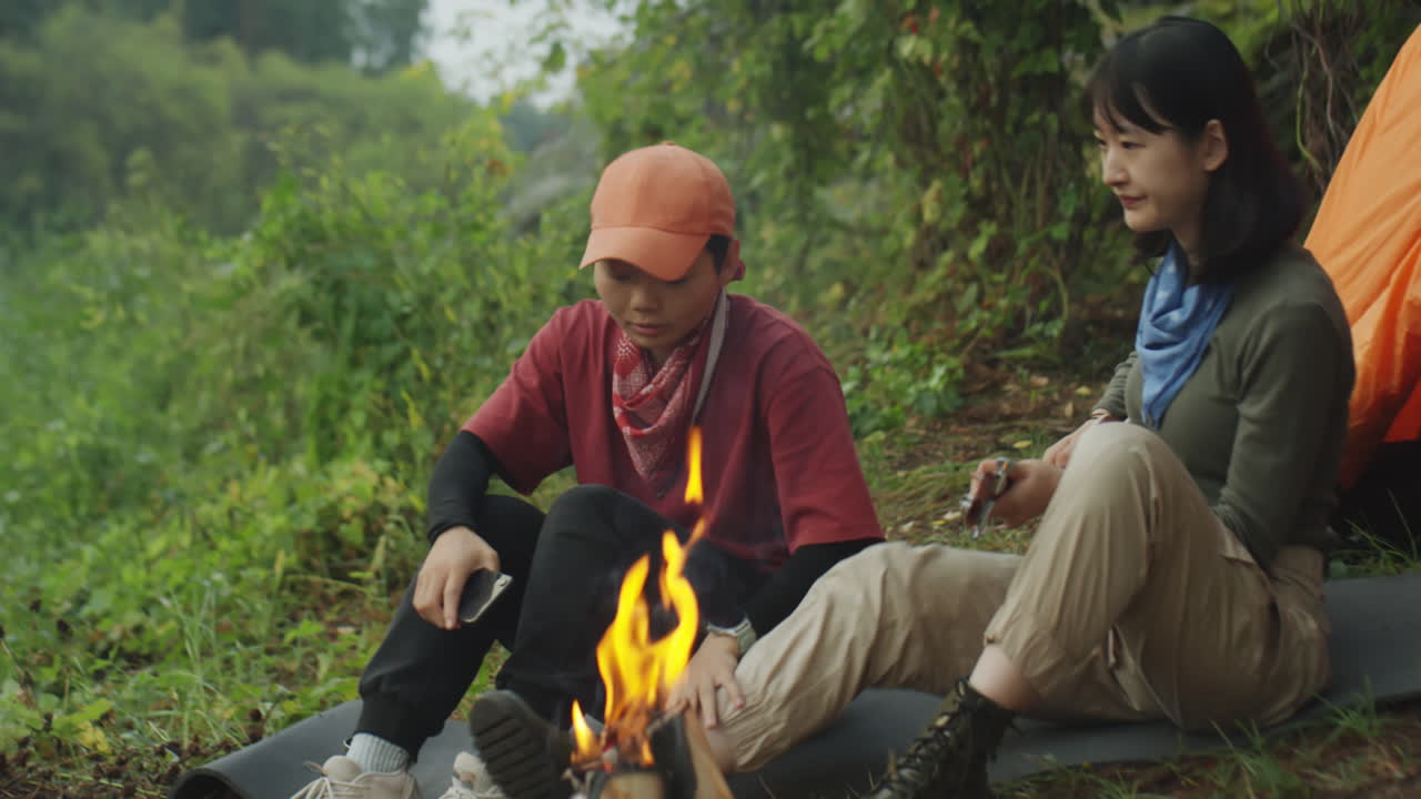 Female Tourists Sitting by Campfire