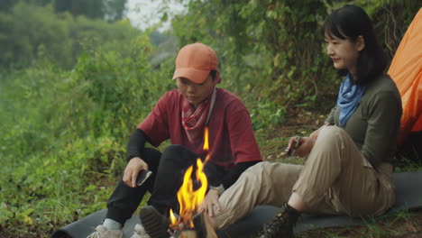 female tourists sitting by campfire