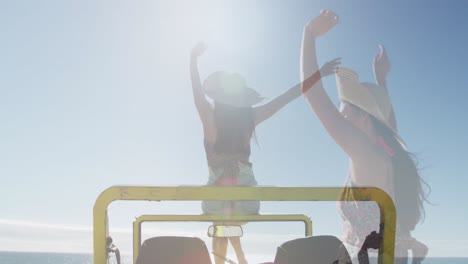 Animation-of-light-over-happy-caucasian-woman-in-car-on-beach