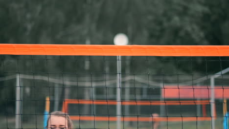 women competing in a professional beach volleyball tournament. a defender attempts to stop a shot during the 2 women international professional beach volleyball.