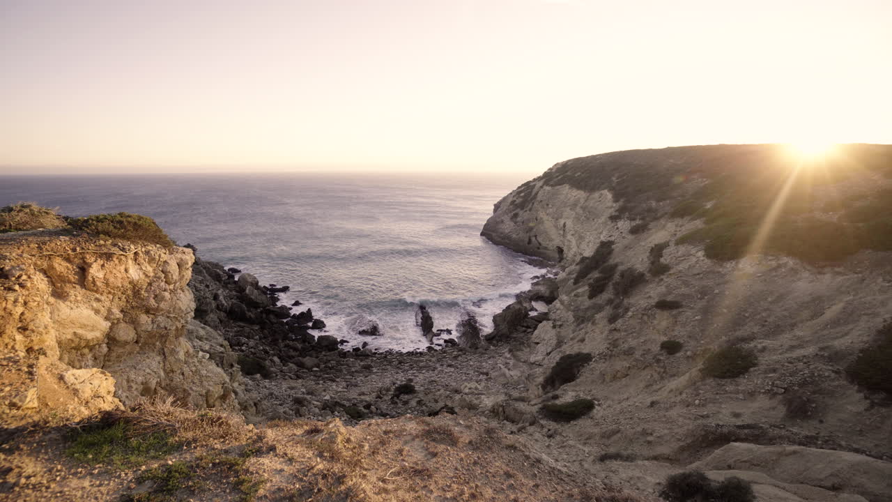 the sun sets while overlooking a beautiful canyon at the beach