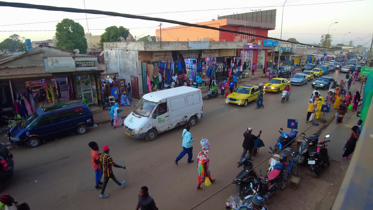 Busy African market street in Serekunda City with heavy traffic congestion at sunset, Gambia