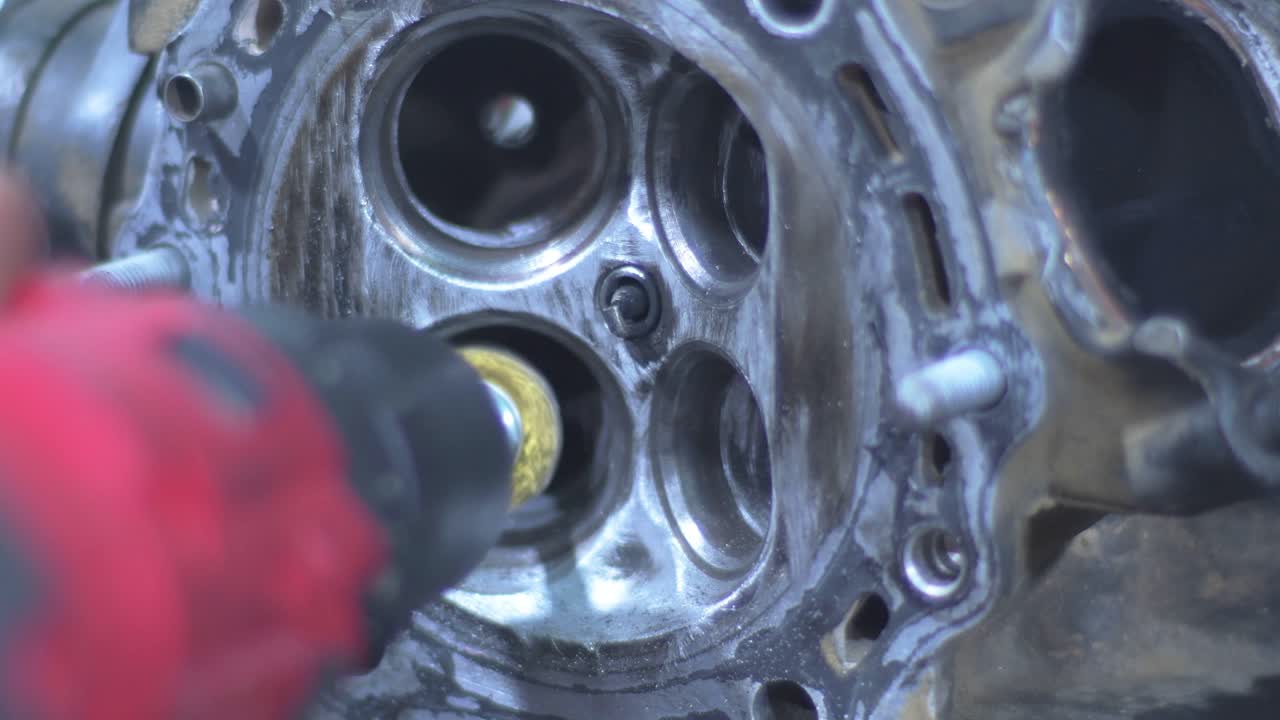 Engine cylinder head motorbike being cleaned with rotary tool, showing valves and metal surfaces. Static shot Engine Upgrade or Rebuild.