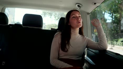 woman sits in taxi and dances enjoying traveling