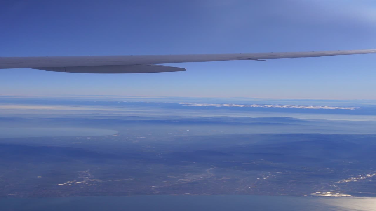 Udsigt fra fly over bjerge og bybillede