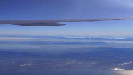 airplane view of mountains and cityscape from above