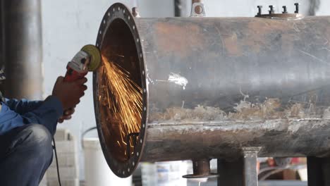 industrial worker cutting and welding metal with many sharp sparks