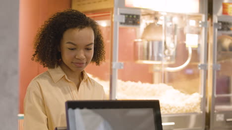 portrait of a smiling woman working at the cinema and looking at the camera