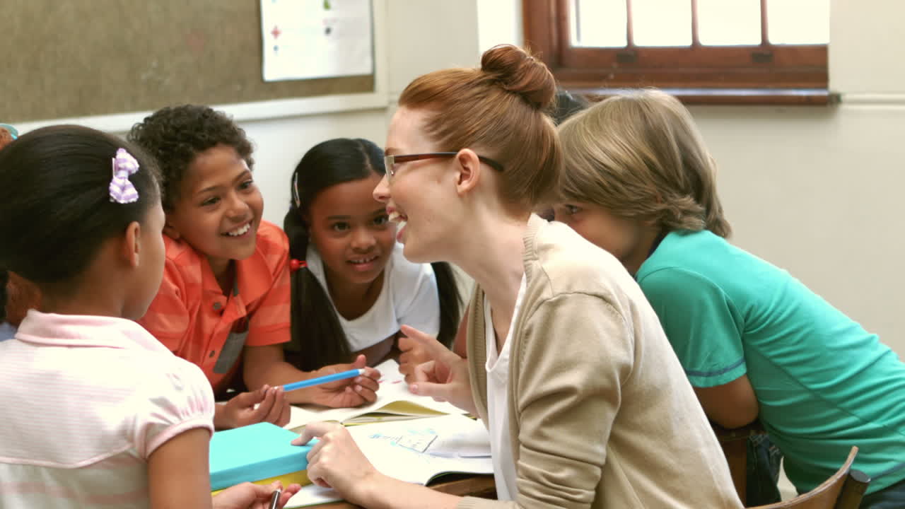 Teacher and pupils working at desk together