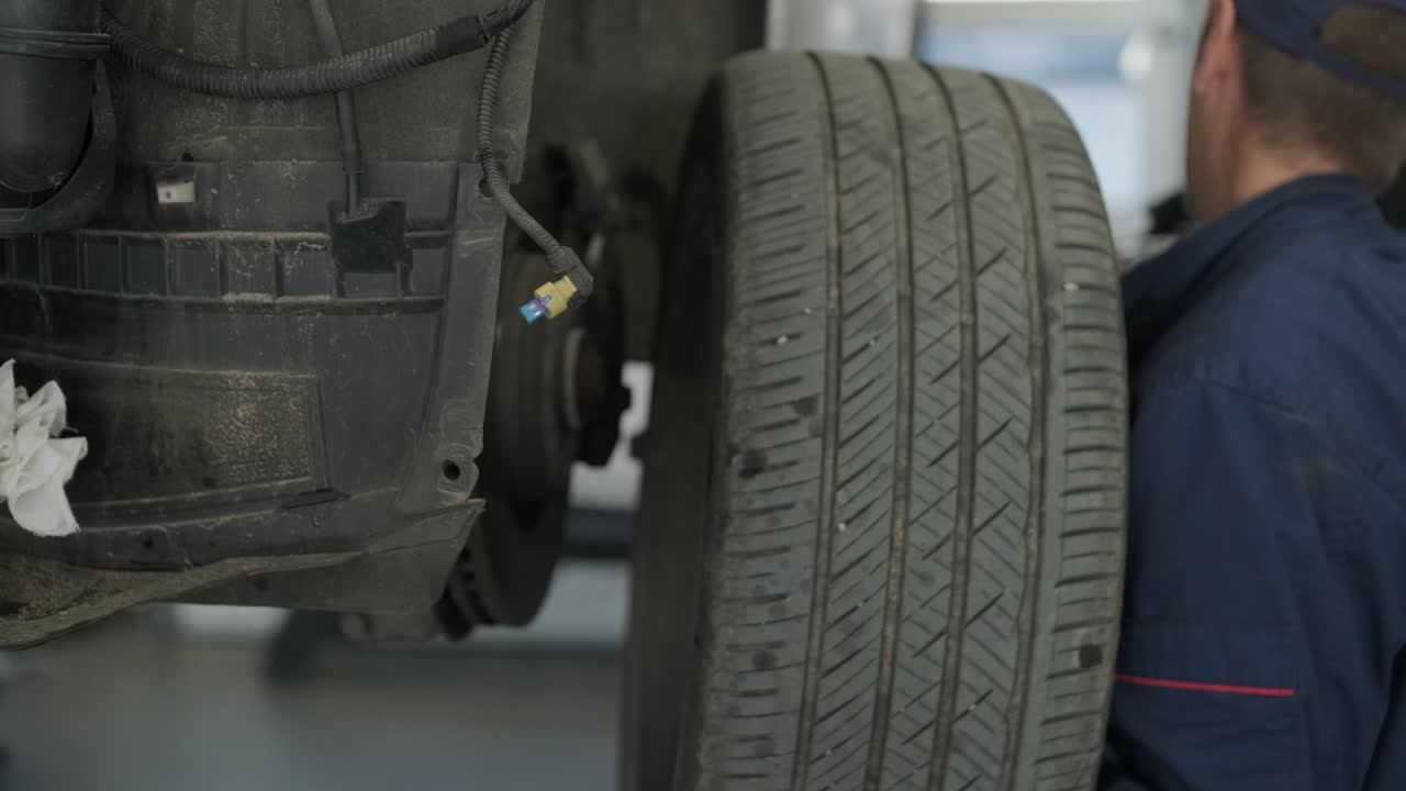 mecánico cambiando la rueda del coche con llave inglesa de impacto