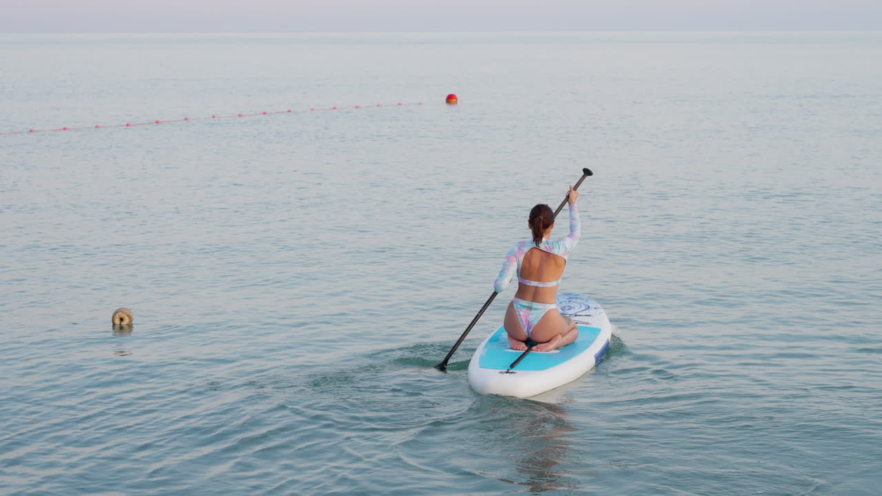 una mujer haciendo paddleboard en el océano.
