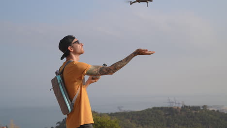 drone landing on travel videographer hand after flight