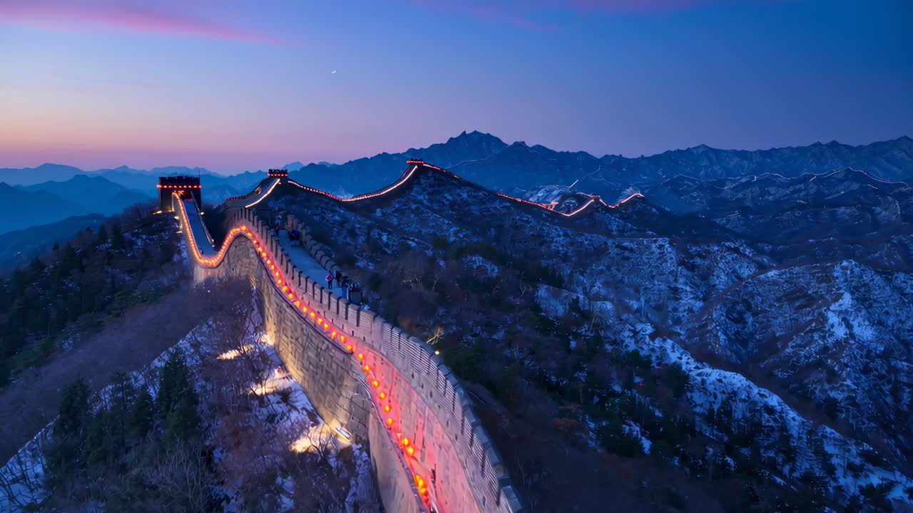 Luftaufnahme-Video der Chinesischen Mauer bei Sonnenuntergang, das leuchtende Laternen und weite Landschaften zeigt.