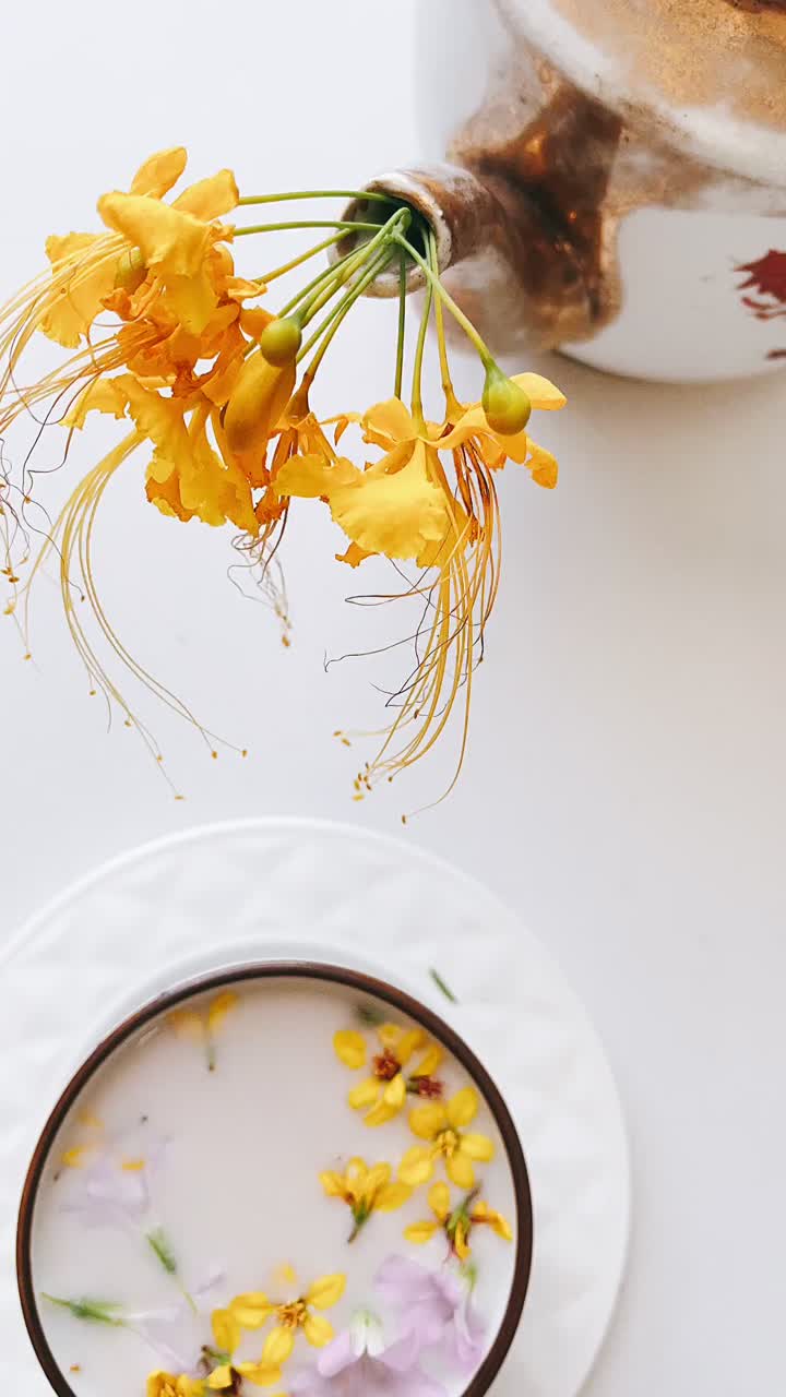 arreglo de teteras y flores con un postre de leche