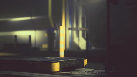 industrial setting with yellow and gray platform illuminated in low light