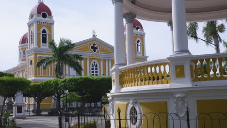 yellow cathedral from rotunda in central park in granada, nicaragua