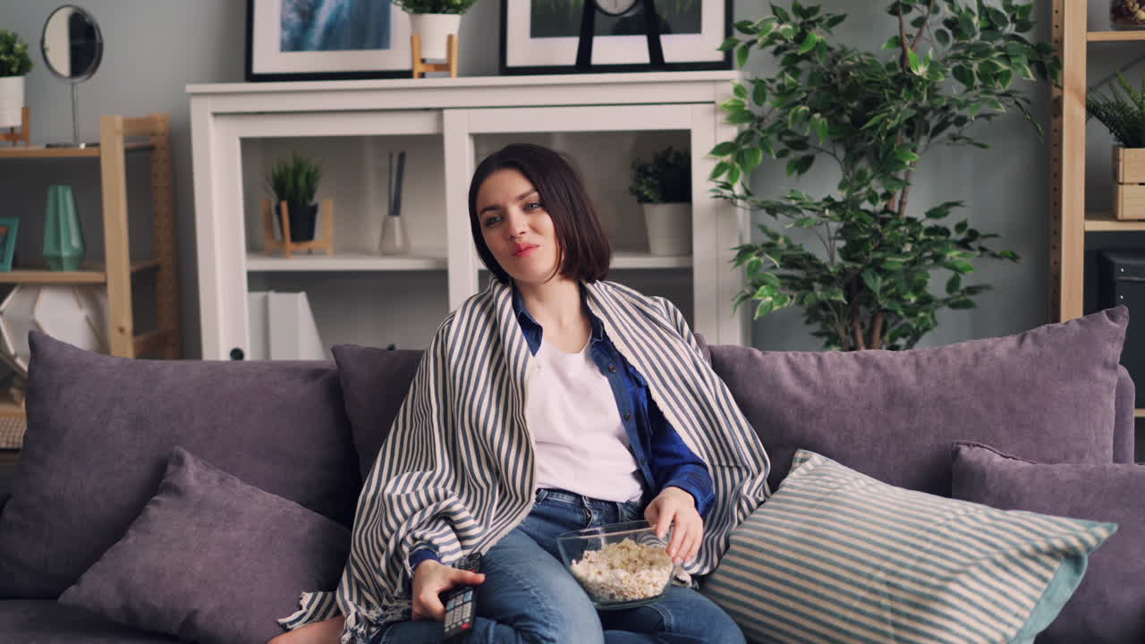 Woman Relaxing on Sofa Watching Movie with Popcorn