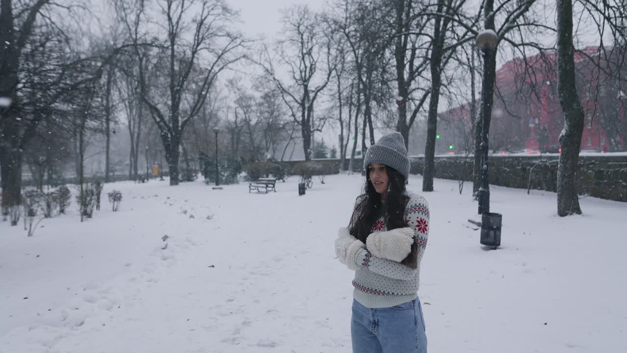 눈이 내리는 동안 공원에서 있는 여자