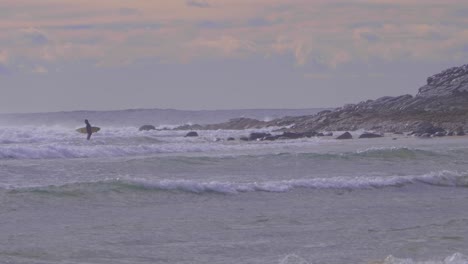 Surfista-Sosteniendo-Una-Tabla-De-Surf-En-El-Mar-Con-Olas-Intensas---Surf-En-Crescent-Head,-Nsw,-Australia---Gran-Plano