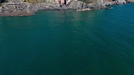 calm, clear water with a view of rocky shoreline, seen from an aerial perspective near manarola, cinque terre, italy