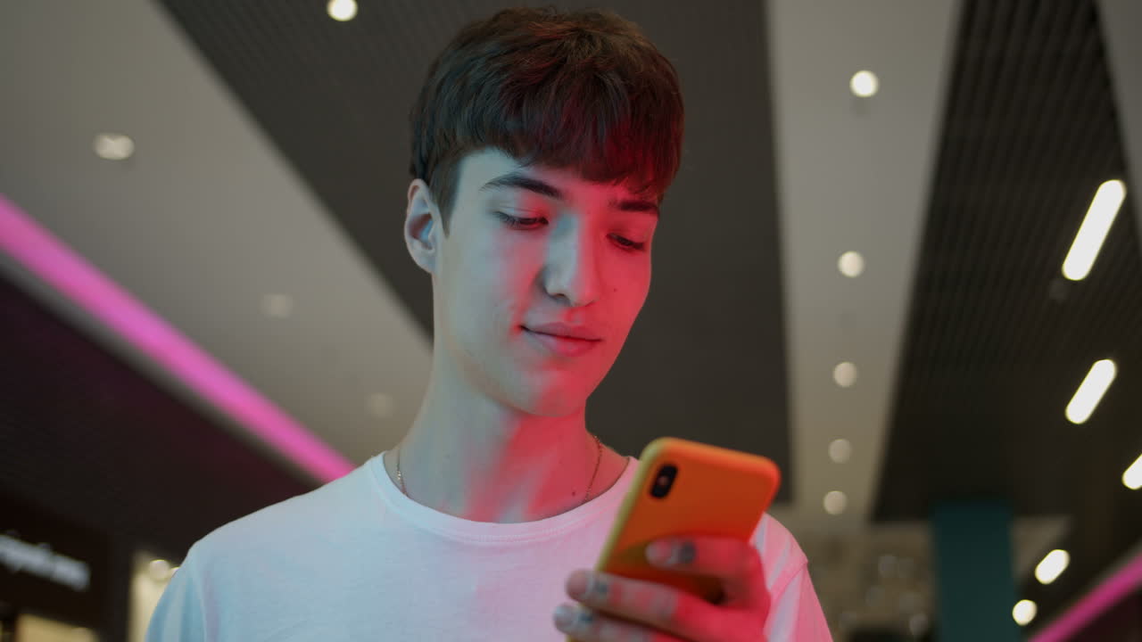 Man using a phone under neon lights