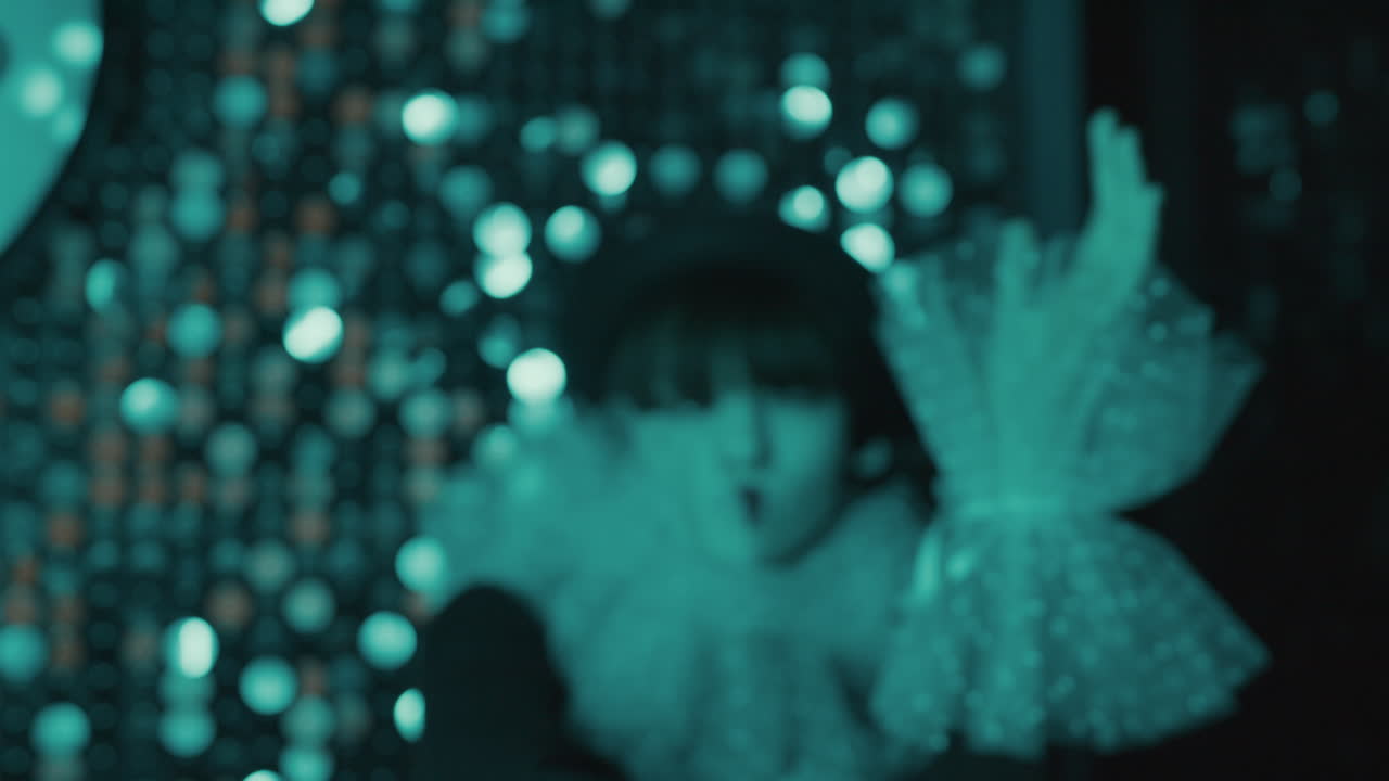 Camera zooming on young woman leaning on a bright wall