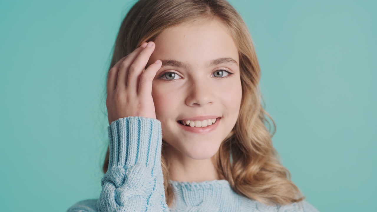 십대 백인 소녀가 카메라를 쳐다보고 있습니다.