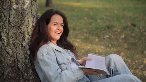 mujer leyendo un libro en un parque