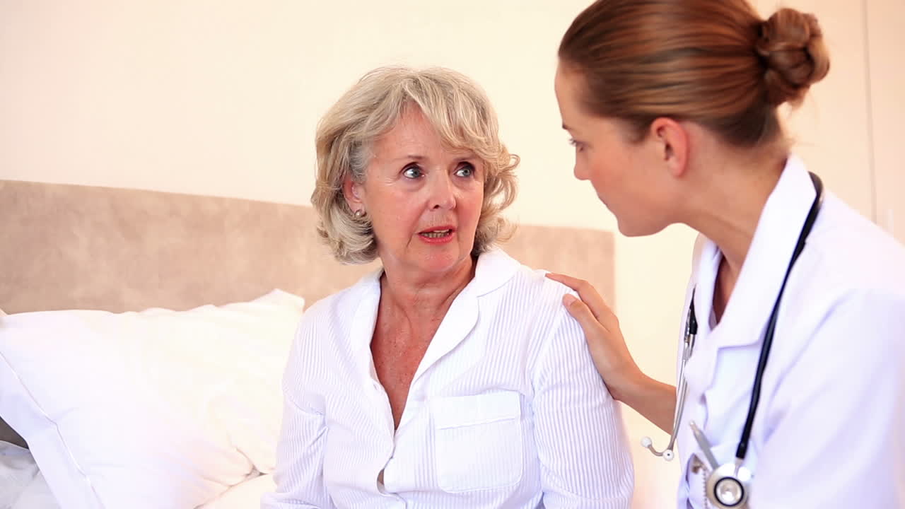 가정 간호사가 노인 환자와 대화하고 있습니다.