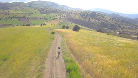 una agricultora iraní caminando por su granja de trigo