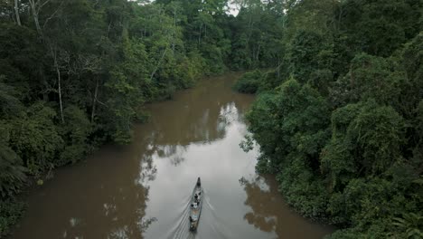 Ascending-Aerial-view-showing-people-sitting-in-kayak-boat-and-cruising-in-amazon-rainforest