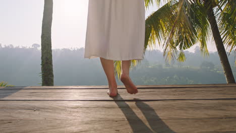 travel woman legs walking on deck with beautiful view of tropical jungle from sunrise 4k vacation lifestyle