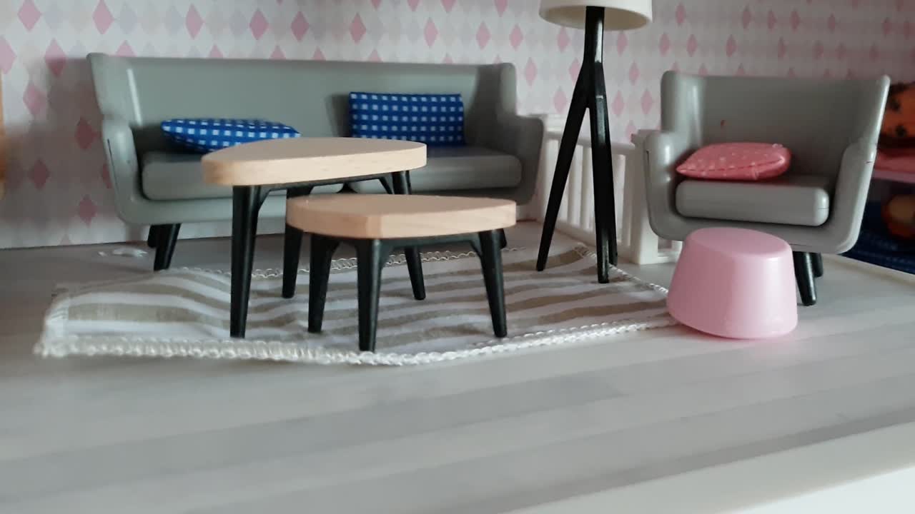 예쁜 미니어처 인형 집에서 현실적인 거실의 팬 샷을 닫습니다.