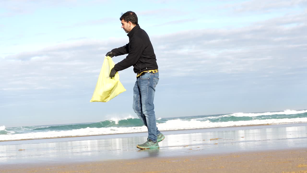 Man picking up trash on the beach