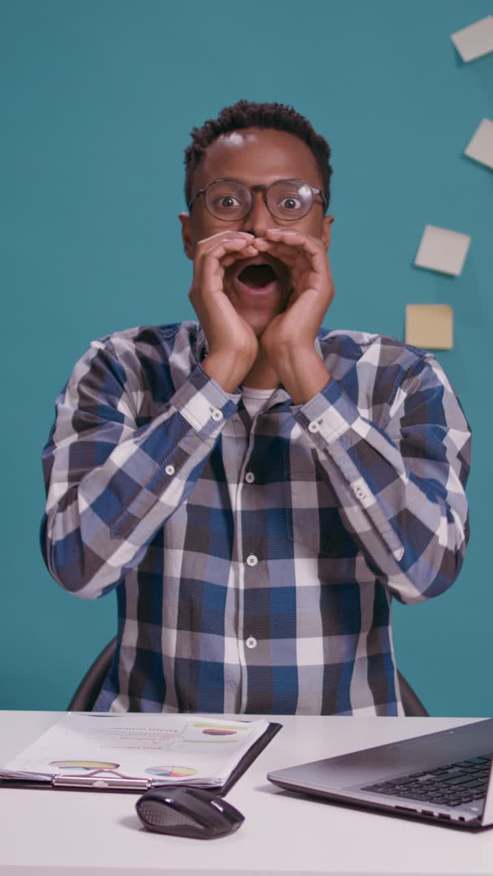 Excited businessman shouting at desk