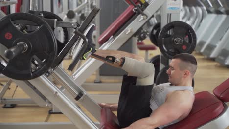 Motivated-disabled-male-with-prosthetic-leg-excercise-his-leg-with-heavy-weights