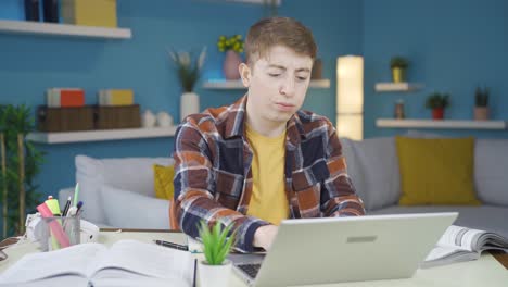 un estudiante enojado mirando la computadora portátil.