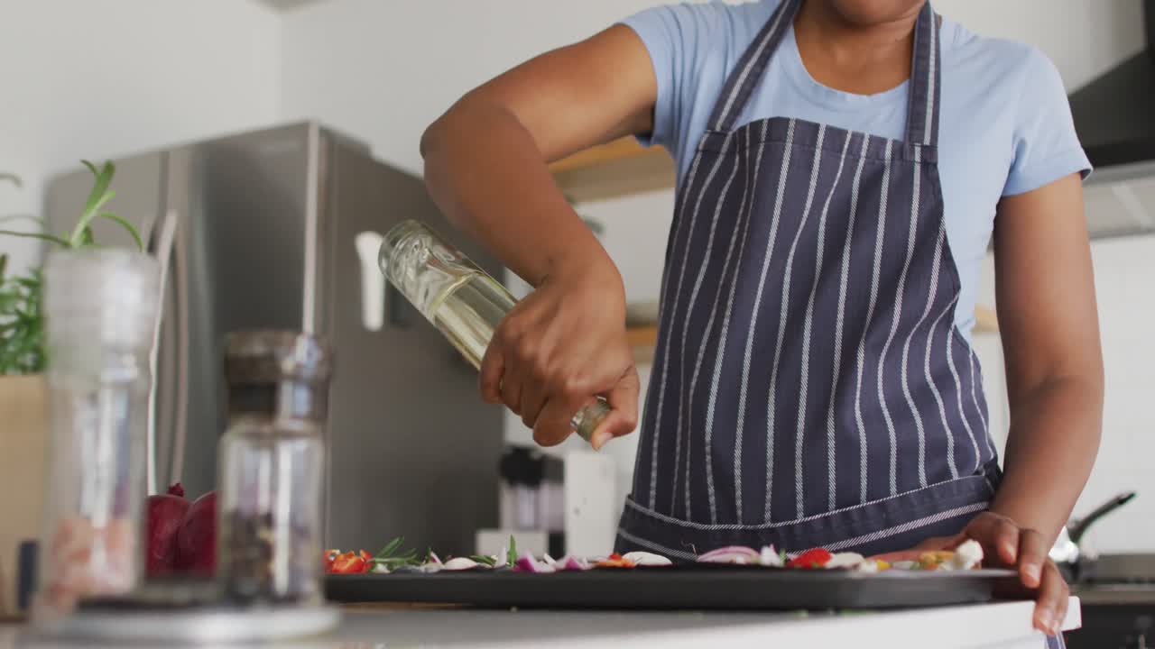 feliz mujer afroamericana preparando la cena en la cocina