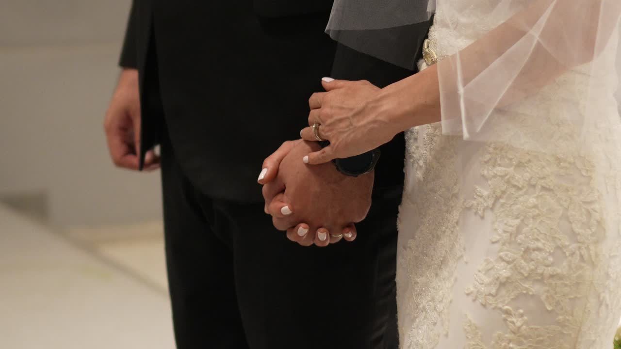 novia y novio tomados de la mano frente al altar en la iglesia durante su día de bodas