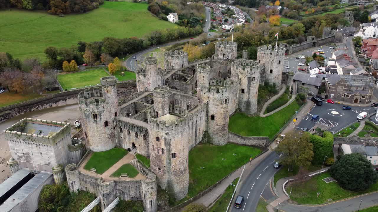Vista aerea dello storico Castello di Conwy, monumento della città in rovina con mura in pietra e merlature, attrazione turistica, inquadratura finale in allontanamento e ascesa